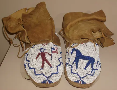 A moccasin is a shoe made of deerskin or other soft leather, consisting of a sole and sides made of one piece of leather, stitched together at the top, and sometimes with a vamp (additional panel of leather). The sole is soft and flexible and the upper part often is adorned with embroidery or beading, et cetera.