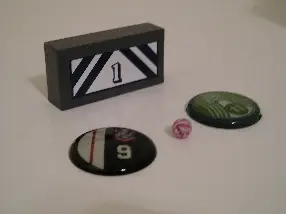 Typical ball, buttons, and goaltender game pieces