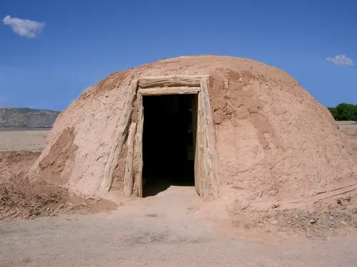 A hogan is the traditional Navajo home. For those who practice the Navajo religion the hogan is considered sacred. The doorway of the hogan was opened to the east so they could welcome the sun. The religious song "The Blessingway" describes the first hogan as being built by Coyote with help from beavers to be a house for First Man, First Woman, and Talking God. The Beaver People gave Coyote logs and instructions on how to build the first hogan. Navajos made their hogans in the traditional fashion until the 1900s, when they started to make them in hexagonal and octagonal shapes. Today they are rarely used as actual dwellings, but are maintained primarily for ceremonial purposes.
