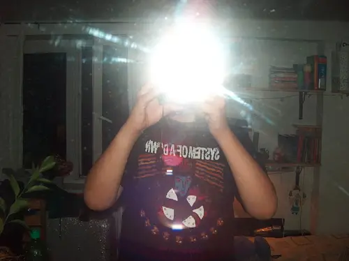 Man photographing himself in a mirror with flash
