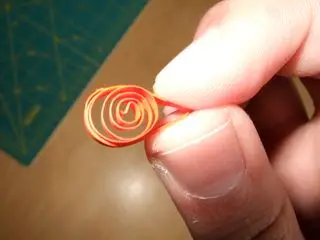 1. To make a teardrop, start out with a loose circle. Pinch one side of the circle into a point